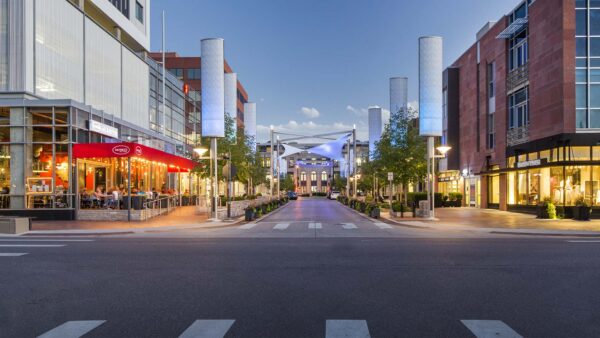Bustling streets in Cherry Creek at dusk with restaurants and boutiques.