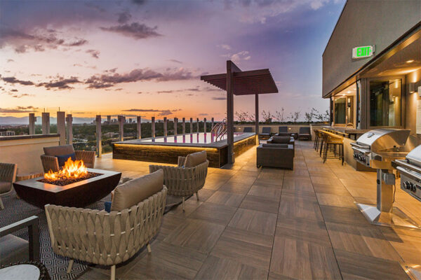 Rooftop lounge with plush seating, fire pit, pool with pergola, and built in BBQ grills.