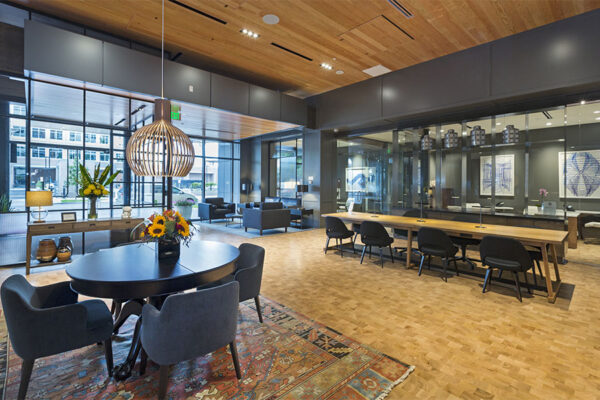 Lounge with large tables, eclectic decor, and glass walls.