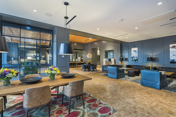 Lounge with wood floor, large rugs, comfortable seating, and eclectic decor.
