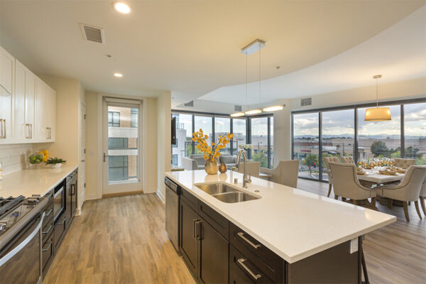 Kitchen with wood floor, dark cabinets, light counters, and floor to ceiling windows.