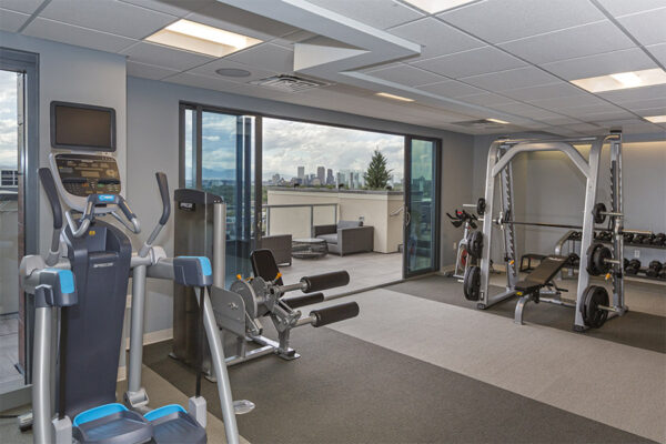 Fitness center with weight equipment, cardio machines, and door to balcony.